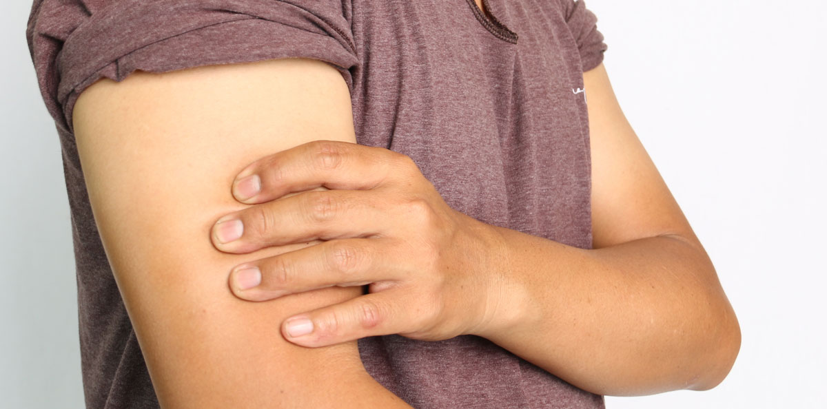 Mann hält sich den Arm