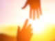 Hände reichen im Sonnenuntergang