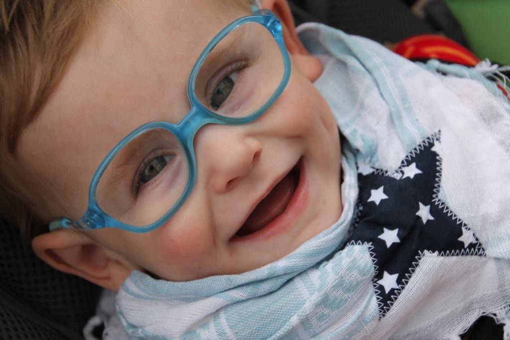 Lachendes Kleinkind mit blauer Brille