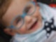 Lachendes Kleinkind mit blauer Brille