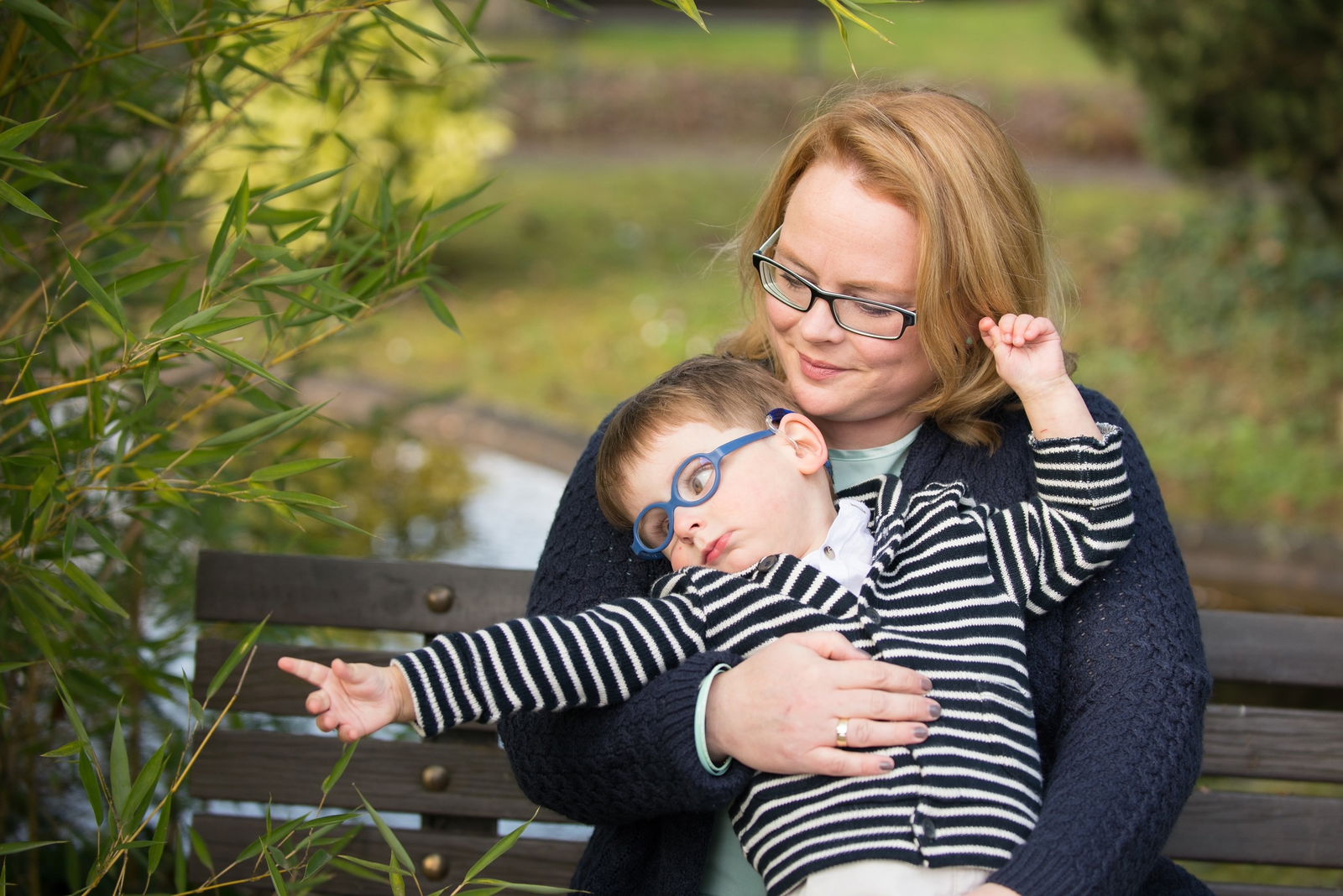 Mutter mit kleinem Sohn im Arm, der mit der Hand zum Busch greift