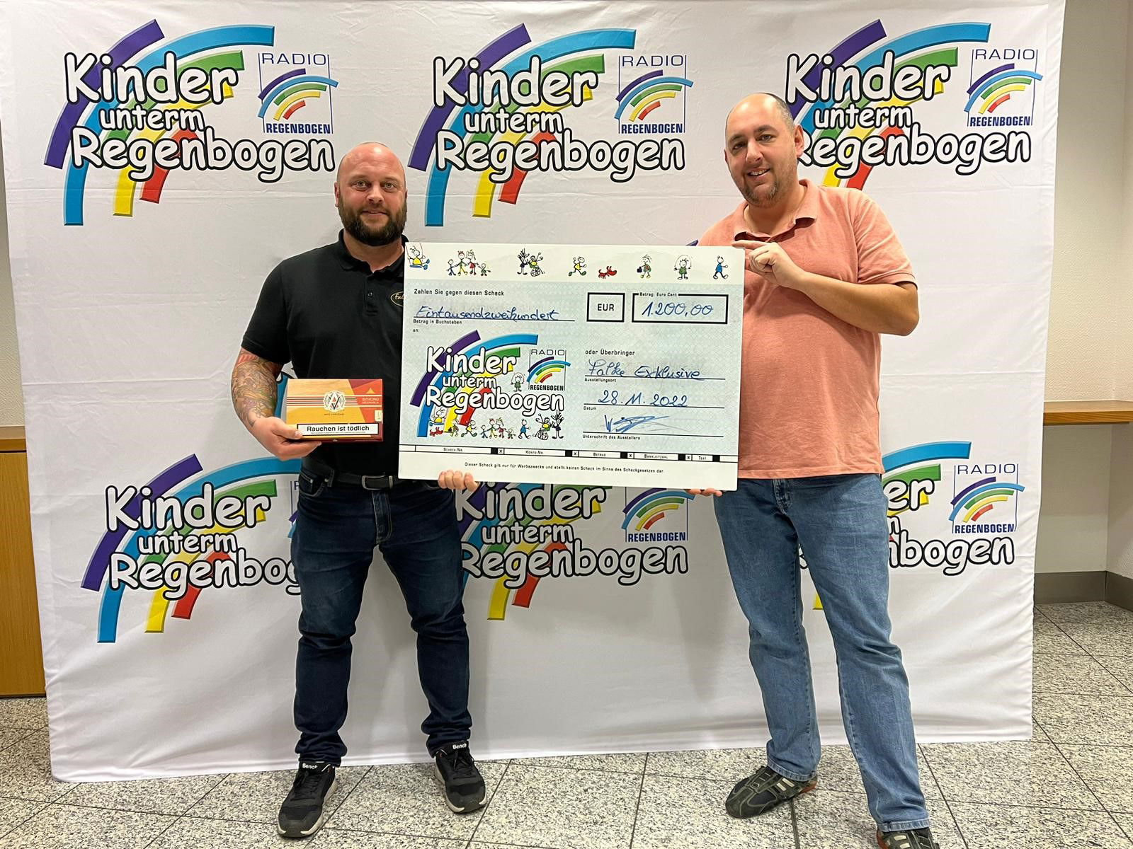 Falke Exklusiv mit Spendenscheck für Kinder unterm Regenbogen