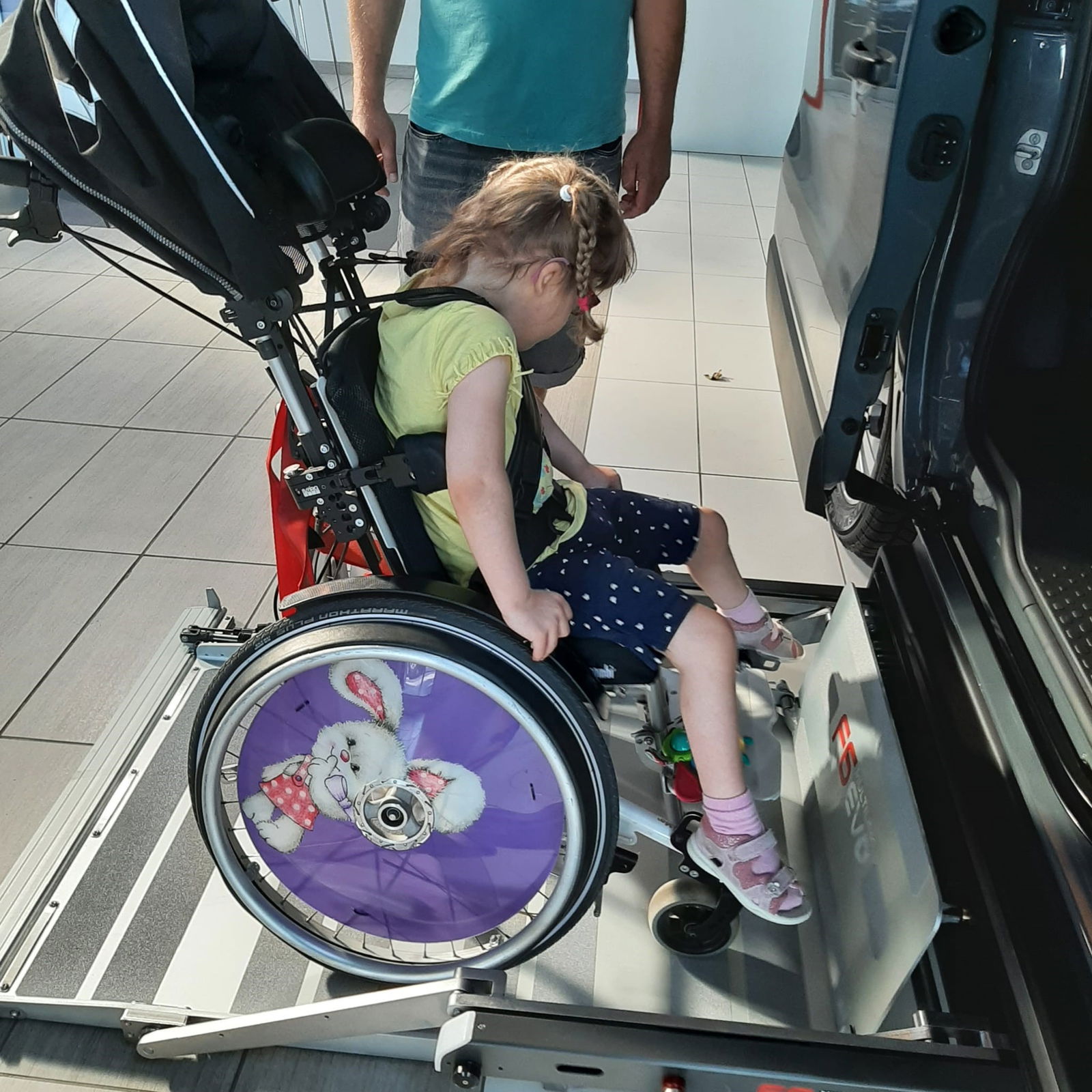 Mädchen im Rollstuhl auf dem Auto-Minilift