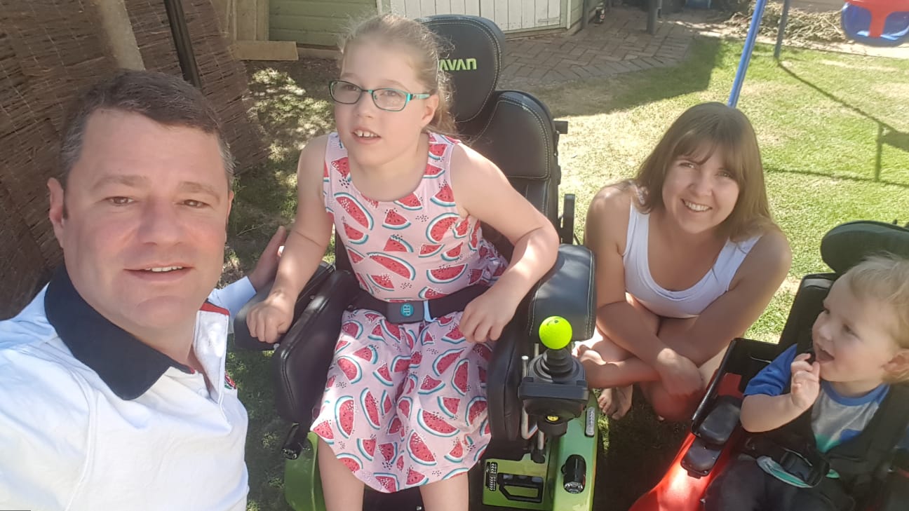 Vater, Mutter mit beiden Kindern in ihren Rollstühlen