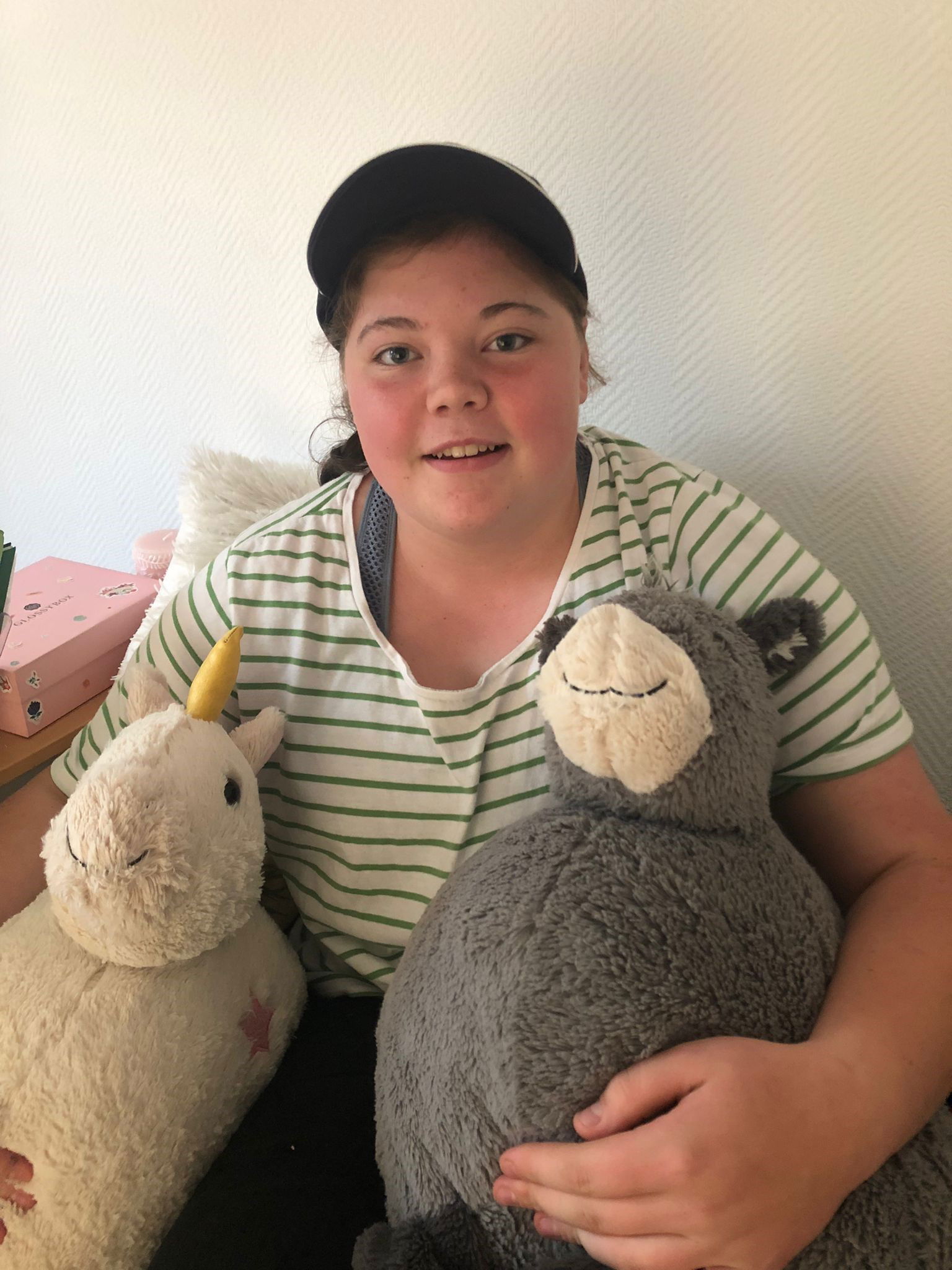 Herzkranke Johanna mit ihren Stofftieren im Arm