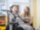 Junge Frau mit lachendem Jungen im Rollstuhl