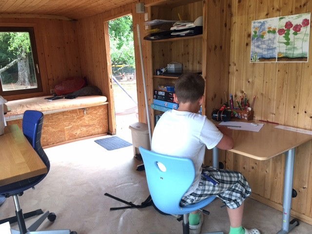 Junge am Schreibtisch in Schulbauwagen