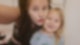 Kleines Mädchen mit langen blonden Haaren und Zahnlücken strahlt mit ihrer Mutter, die ein Selfie von ihnen macht