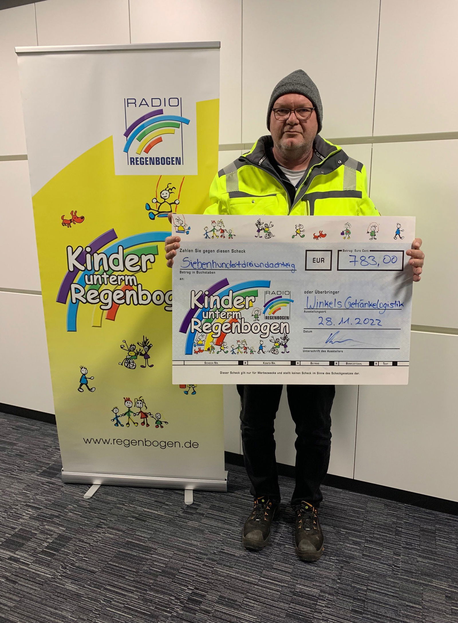 Mann von Winkel Getränkelogistik mit Spendenscheck von 783 Euro