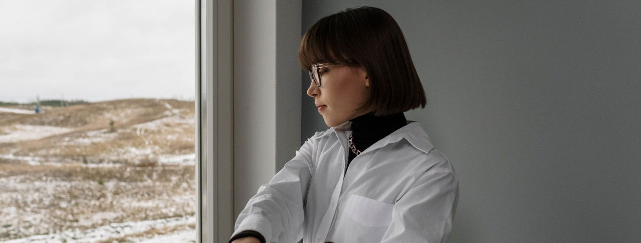 Frau schaut aus dem Fenster