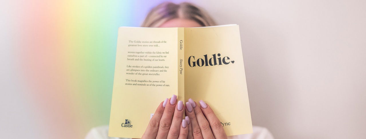 Eine Blondine hält sich ein Buch vor das Gesicht 