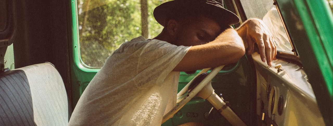 Mann an Steuer vorgelehnt