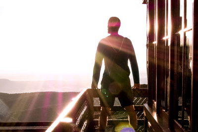 Ein Mann blickt breitbeinig stehend auf den Horizont 