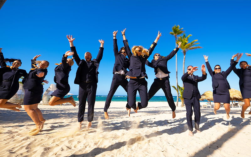 Flugbegleiter:innen springen am Strand in die Luft 