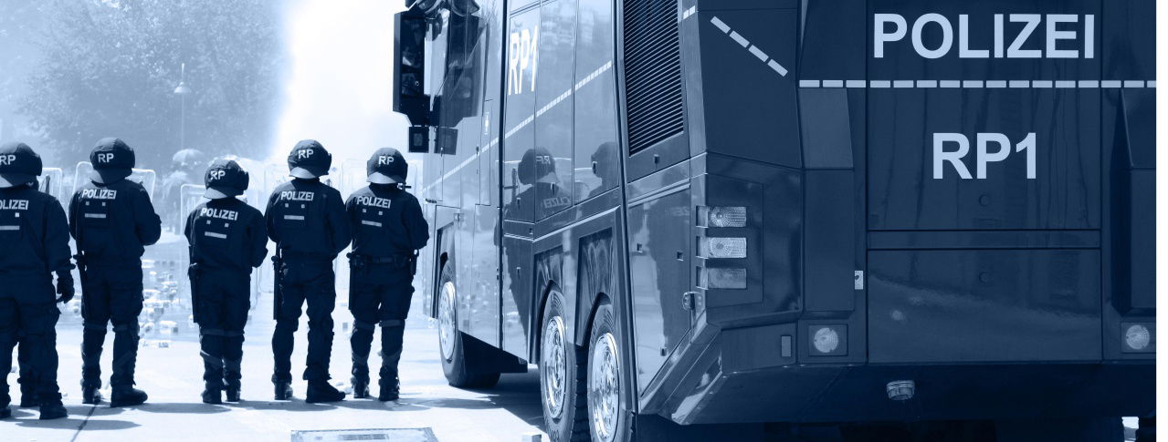 Polizisten vor einem Mannschaftsbus 