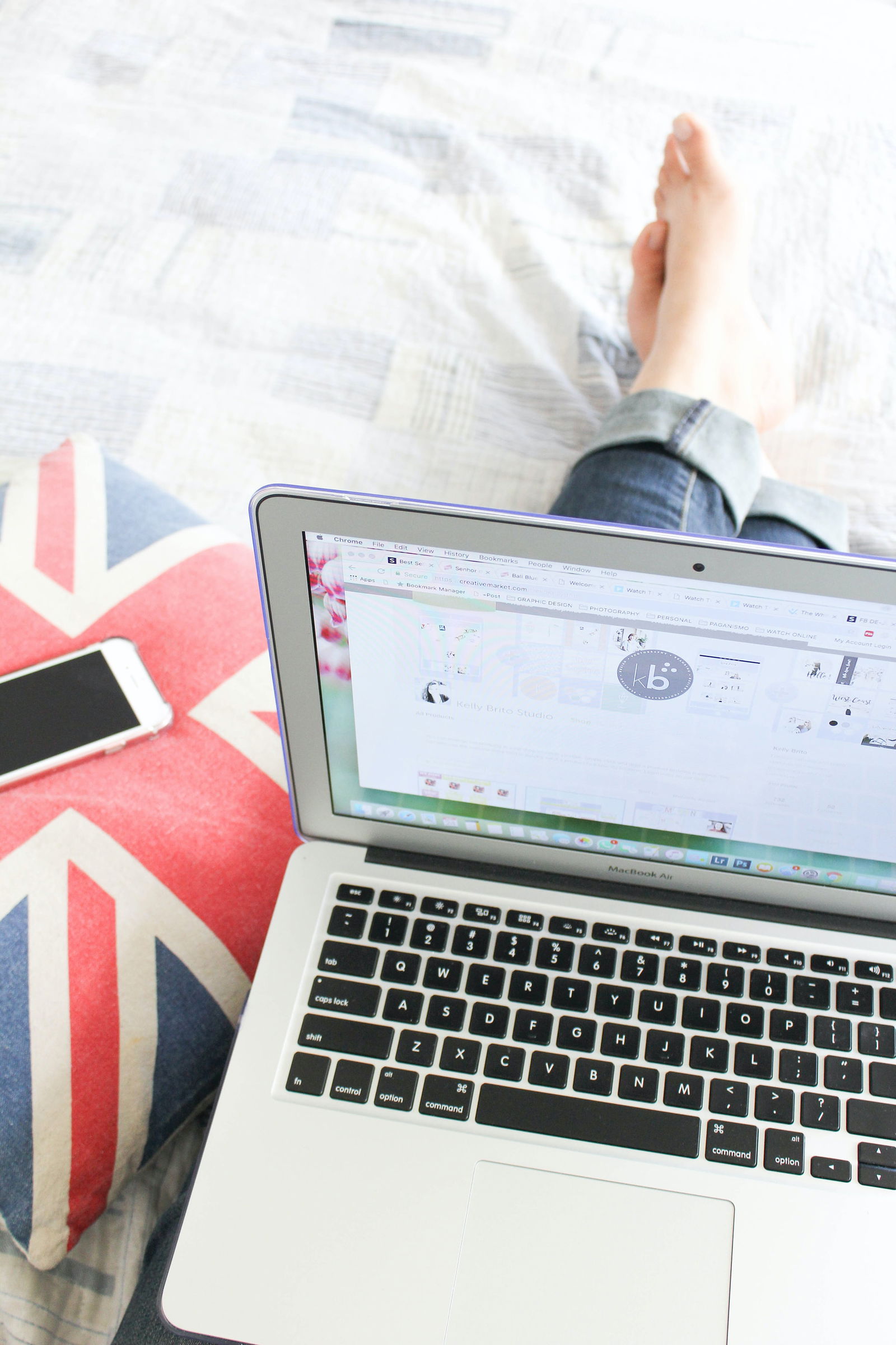 Eine Person sitzt mit einem Laptop auf dem Schoß im Bett 