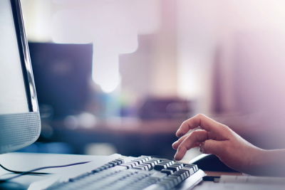 Hand auf Tastatur am Laptop