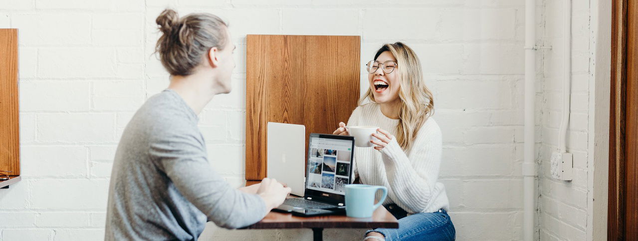 Mann und Frau unterhalten sich, Laptops