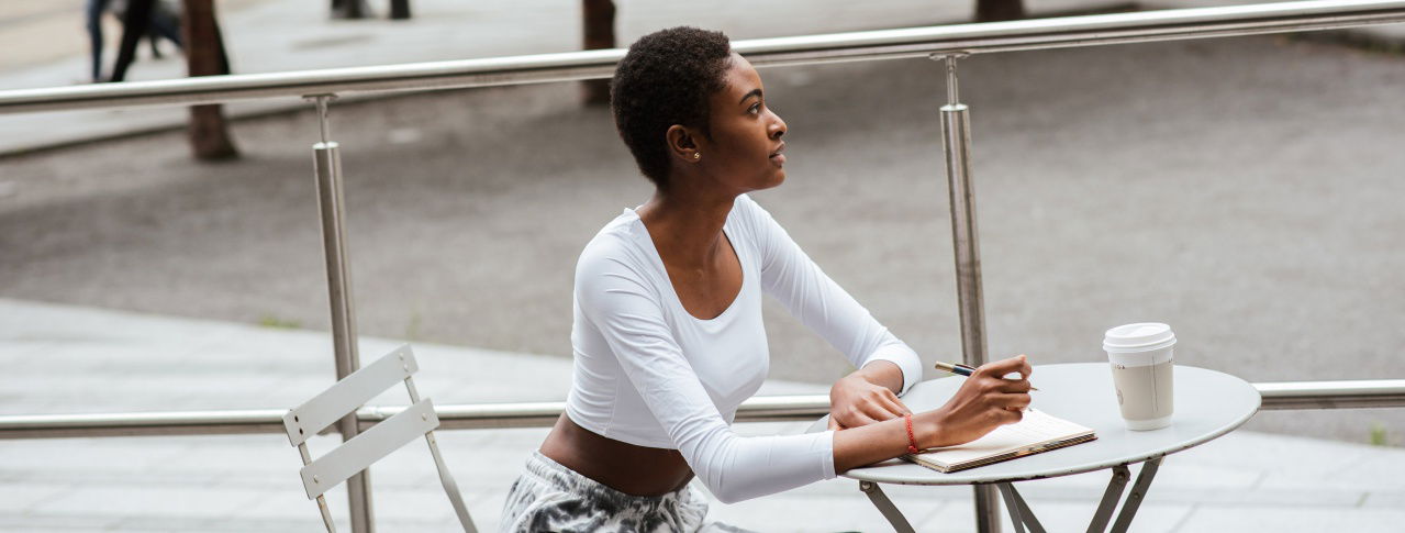 Frau im Cafe & macht sich Notizen