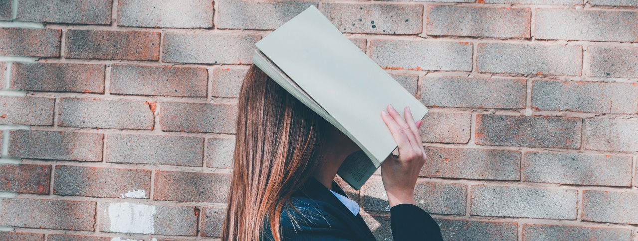 Frau mit Buch über dem Kopf