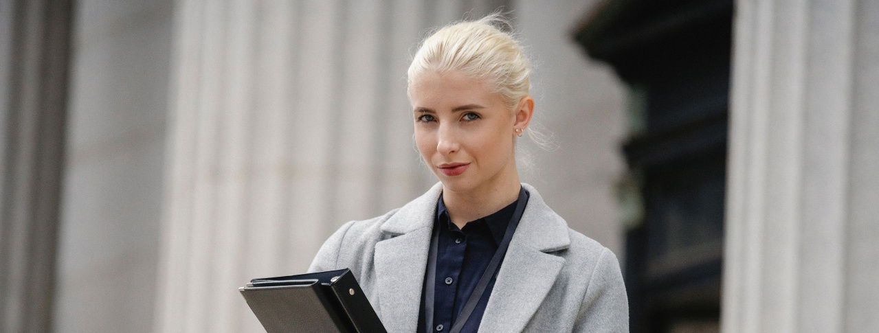 Eine Beamtin hält einen Ordner im Arm 