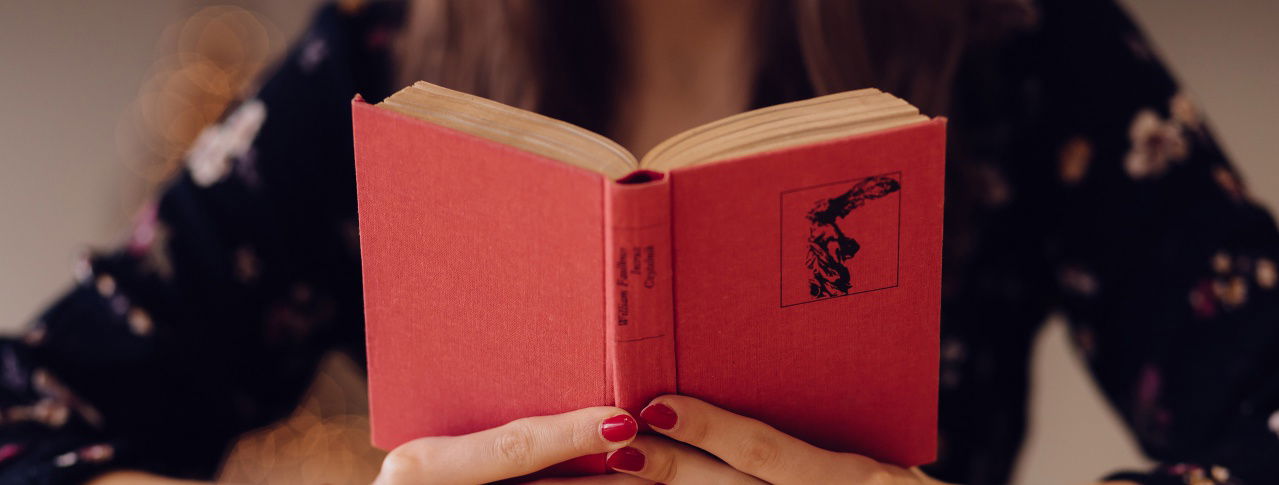 Aufgeklapptes Buch mit Frau im Hintergrund