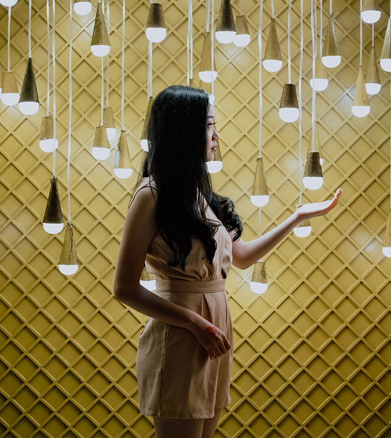 Frau zwischen vielen Glühbirnen