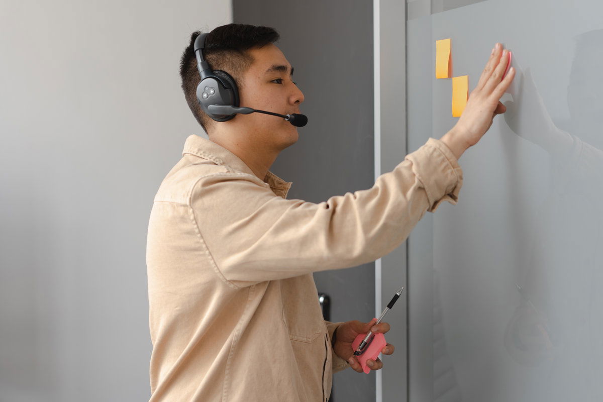 Mann mit Headset an der Tafel