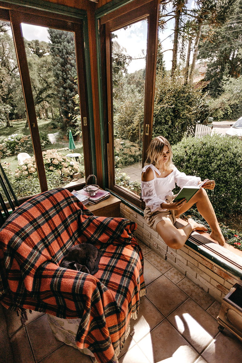 Frau sitzt im Fenster und liest