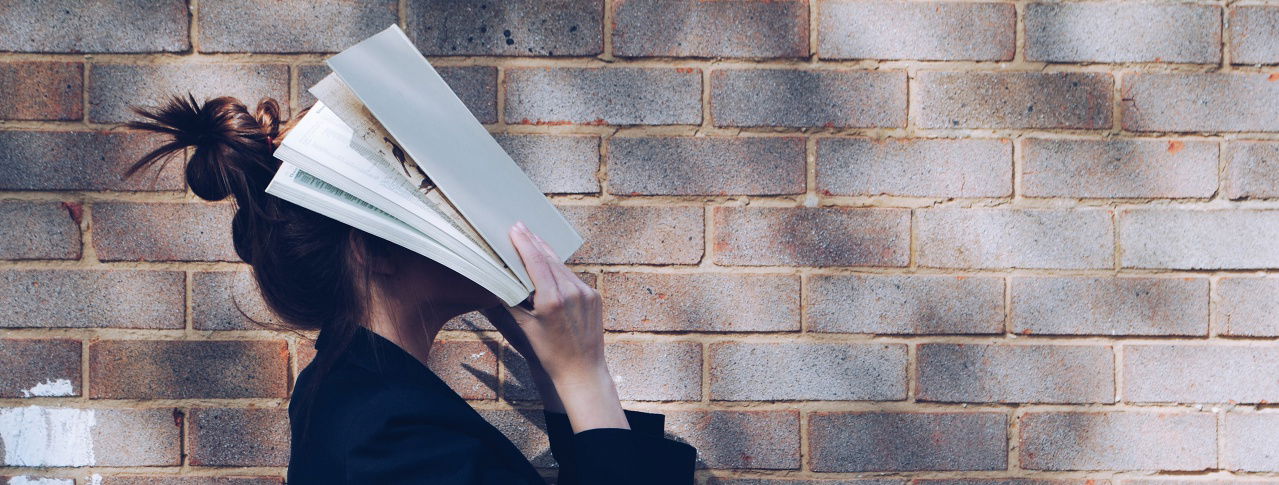 Frau mit buch vor Kopf