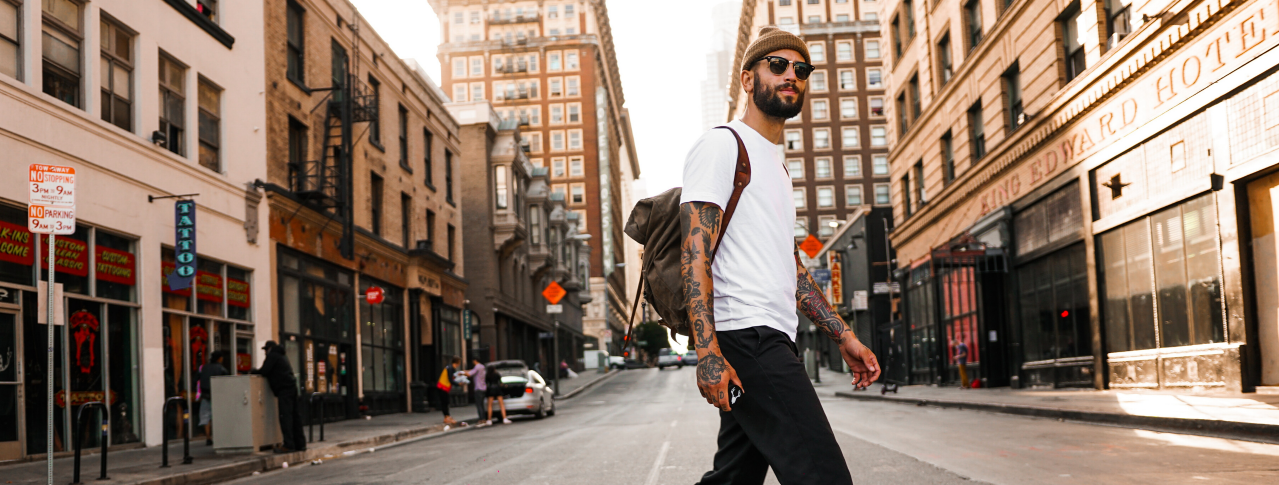 Mann mit Tattos geht über Straße