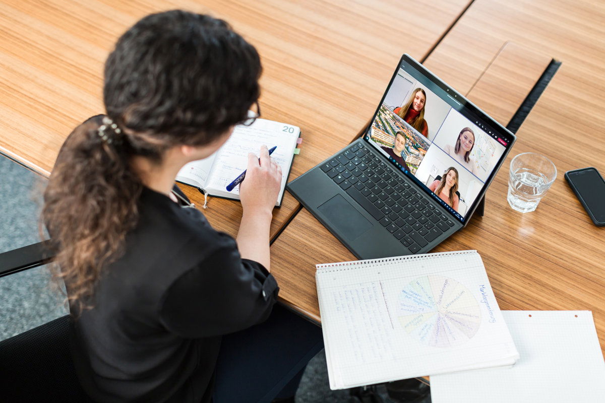 Frau mit Notizblock in Videokonferenz