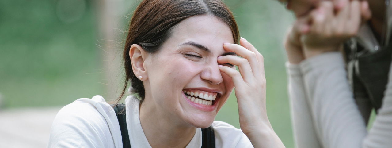 Junge Frau lacht im Grünen