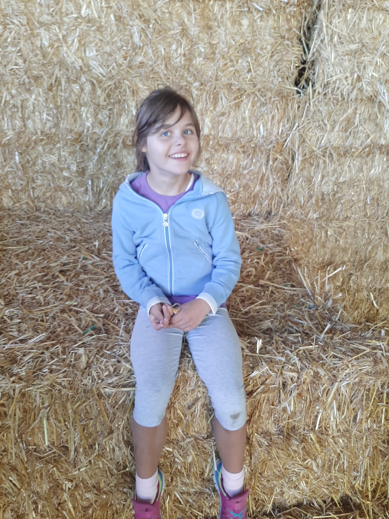 Stella sitzt im Stroh