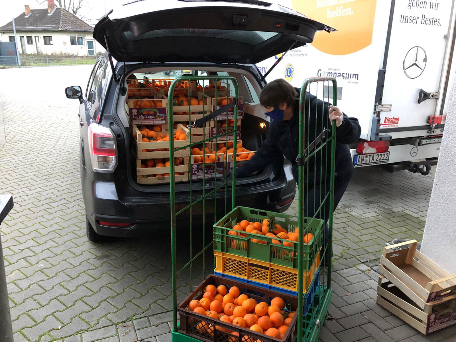 Tafel-Mitarbeiterin lädt Auto aus