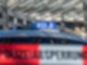 Ein Polizei-Blaulicht leuchtet über einem Absperrband mit der Aufschrift «Polizeiabsperrung».