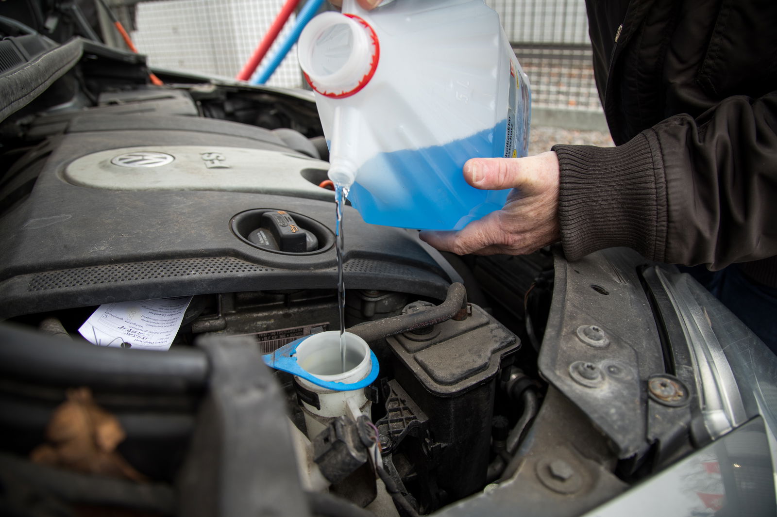 Mann füllt Frostschutz nach