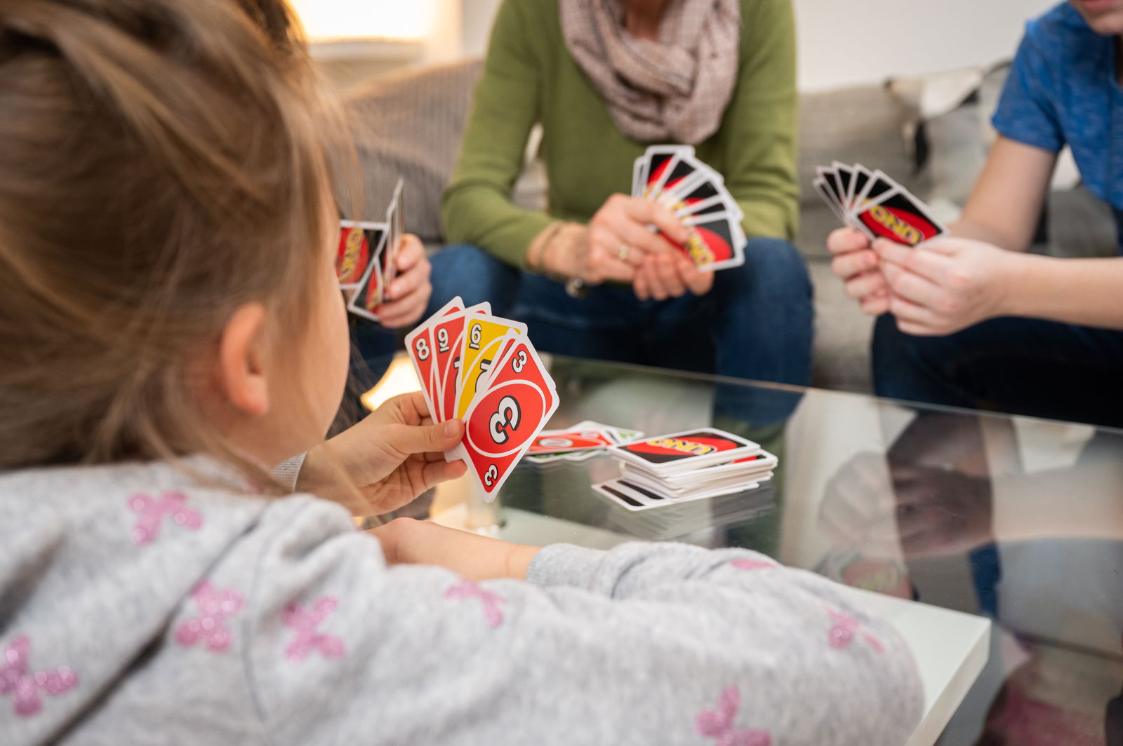 Familie spielt UNO Kartenspiel