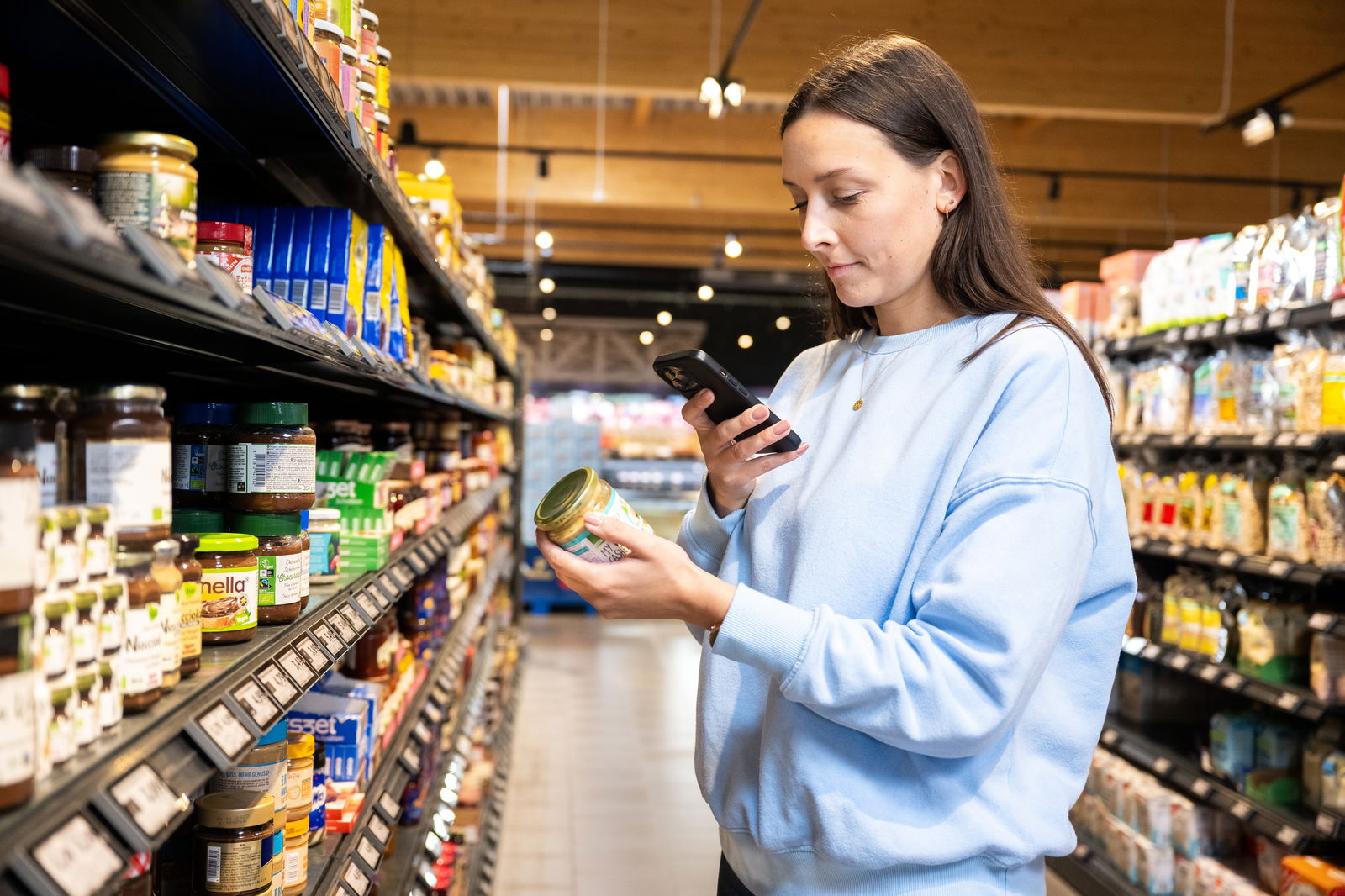 Frau checkt Lebensmittel mit Smartphone