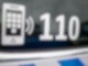 Der Nummer des Polizeinotrufs 110 steht auf der Scheibe eines Polizeifahrzeugs.