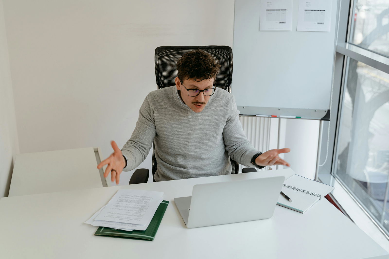 Ein aufgebrachter, wütender Mann spricht in seinen Laptop hinein. 
