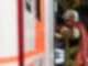 Eine Einsatzkraft der Feuerwehr nimmt während eines Pressetermins einen Schlauch aus einem Einsatzfahrzeug der Feuerwehr Stuttgart (gestellte Szene).
