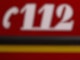Der Notruf "112" ist auf einem Fahrzeug der Feuerwehr zu sehen.