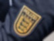 Das Wappen der Polizei Baden-Württemberg ist auf der Uniform einer Polizeibeamtin zu sehen.