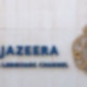 Der Schriftzug und das Logo des arabischen Nachrichtensenders Al-Dschasira sind auf dem Gelände des Unternehmens zu sehen.