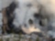 Ein Feuerwehrmann geht durch den Qualm eines brennenden Hauses in Charkiw.