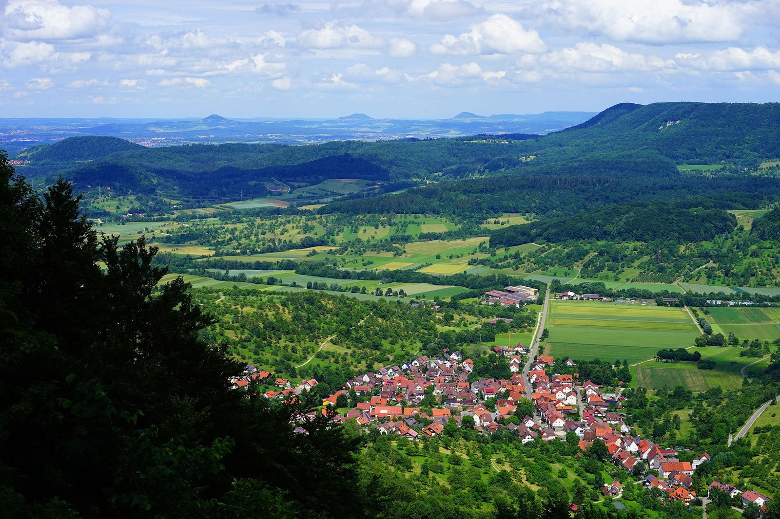 Luftaufnahme einer kleinen Ortschaft am Füße der Berge
