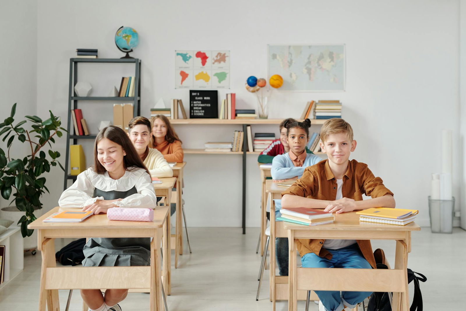 Schülerinnen und Schüler sitzen an ihren Tischen in einem Klassenzimmer