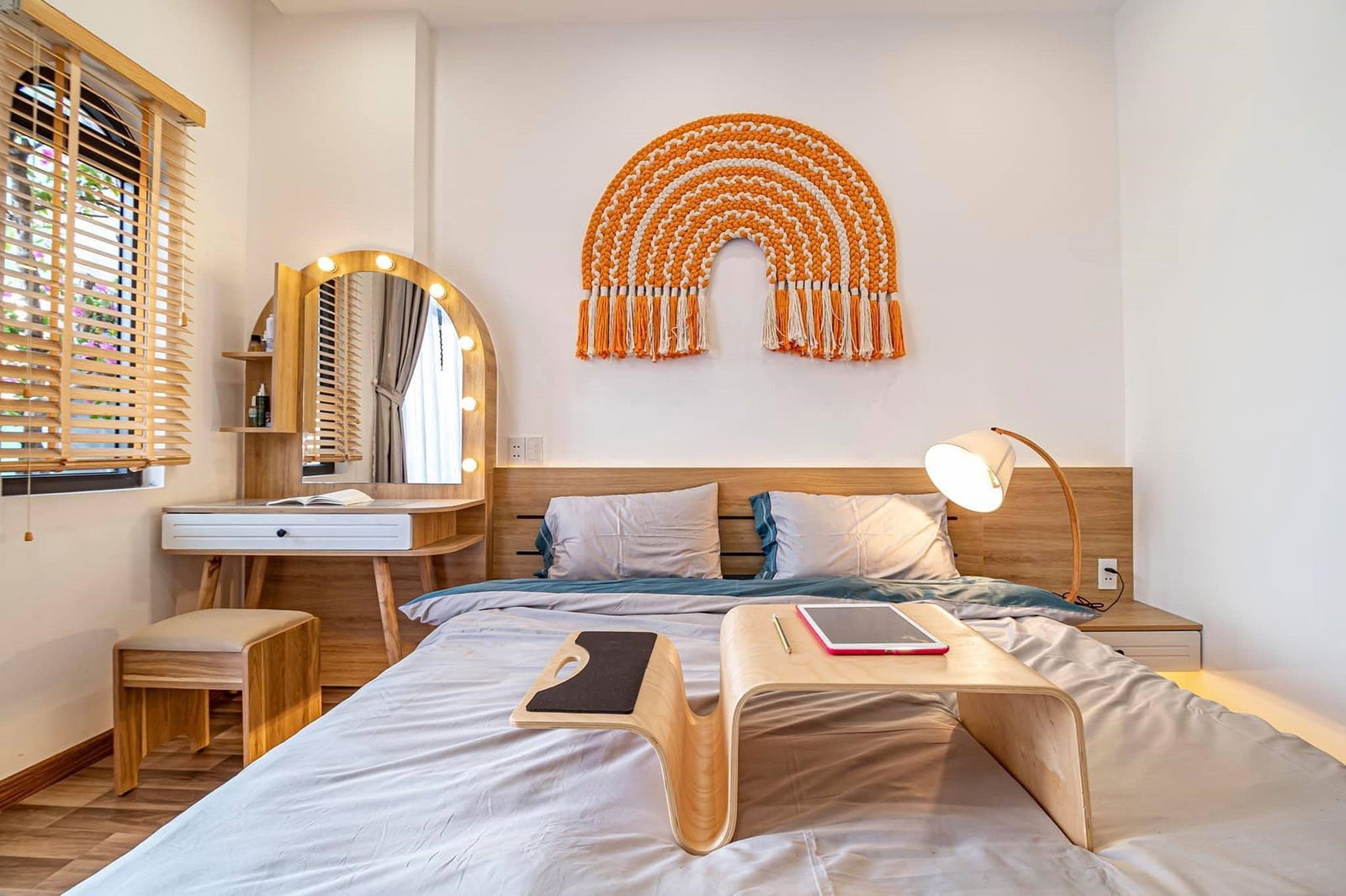 Schlafzimmer mit orangenem Schal und verschiedenen Möbeln aus Holz
