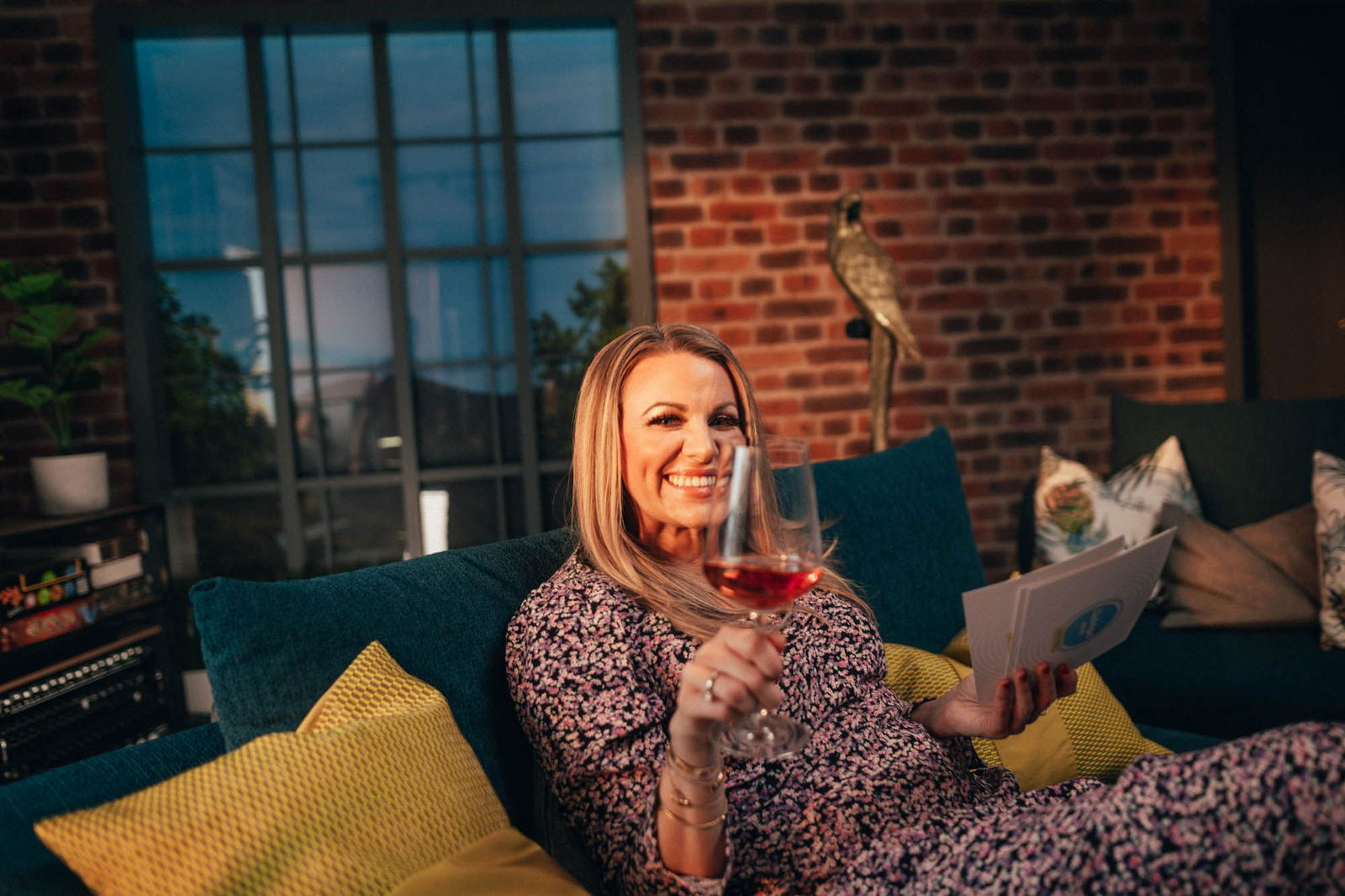 Miriam Audrey Hannah, die Moderatorin von Music Made in Germany, auf dem Sofa mit einem Glas Rotwein